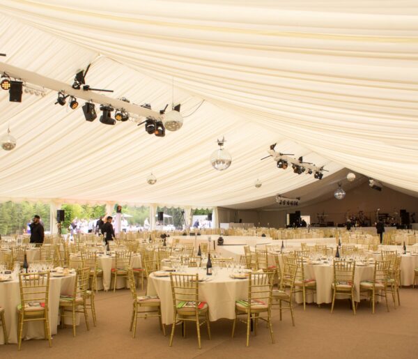 Luxury Clearspan Marquee for Formal Events Luxury clearspan marquee interior with draped ceilings, elegant lighting, and round banquet tables set for a formal event.